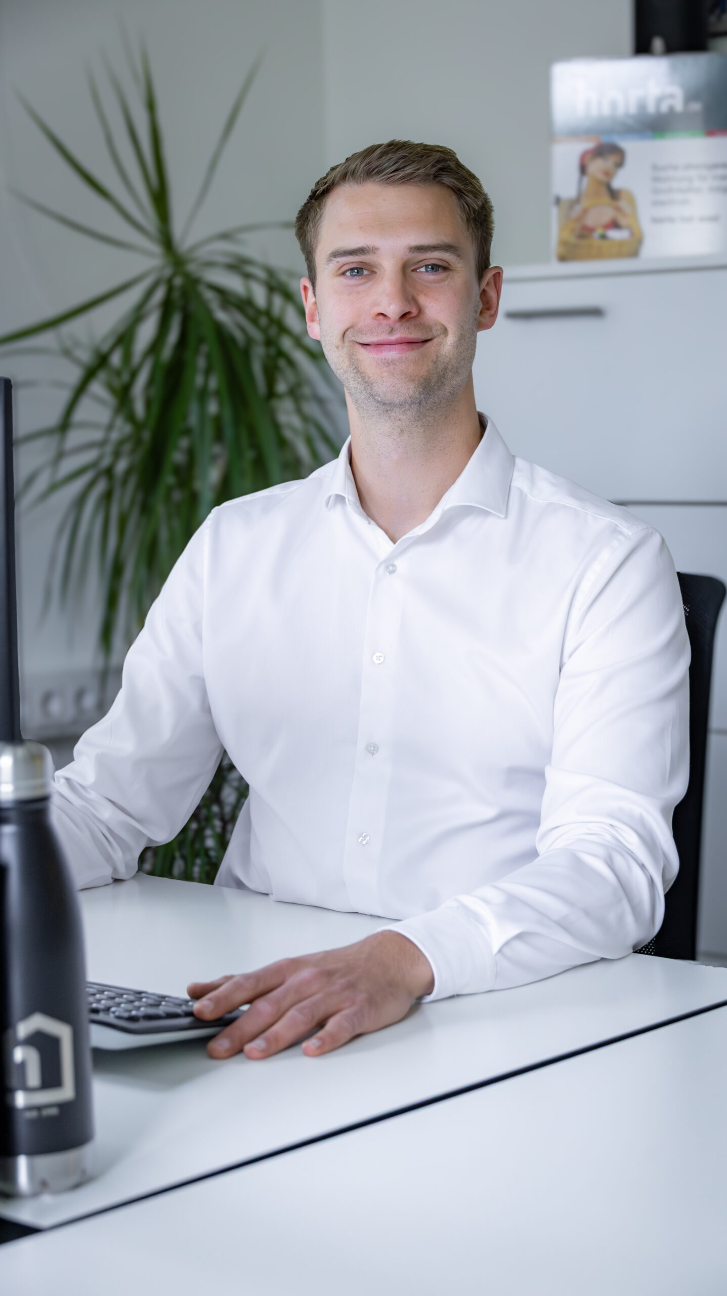 Lukas Mittag Immobilienmakler am Arbeitsplatz lächelnd
